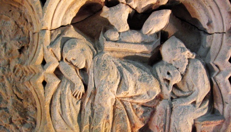 Steingehauertes Bild: Maria und Joseph schlafend, hinter ihnen die Krippe, das Kind, mit wachem Blick Ochs und Esel